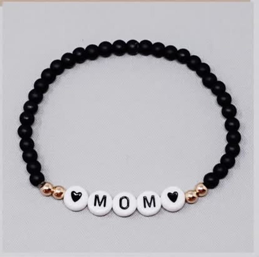 Byzylyk me rruaza të zeza dhe shkronjat «MOM»