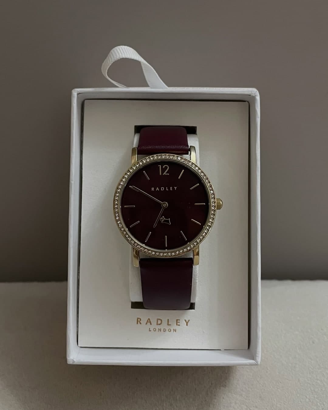 Orë Radley London me fushë bordo dhe gurë rreth kornizës