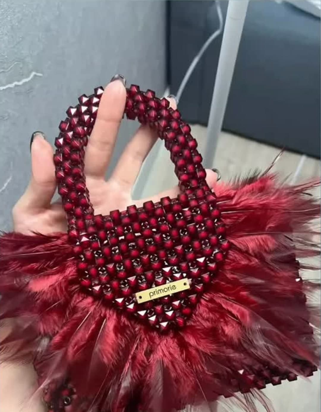 Çantë bordo me rruaza dhe pupla